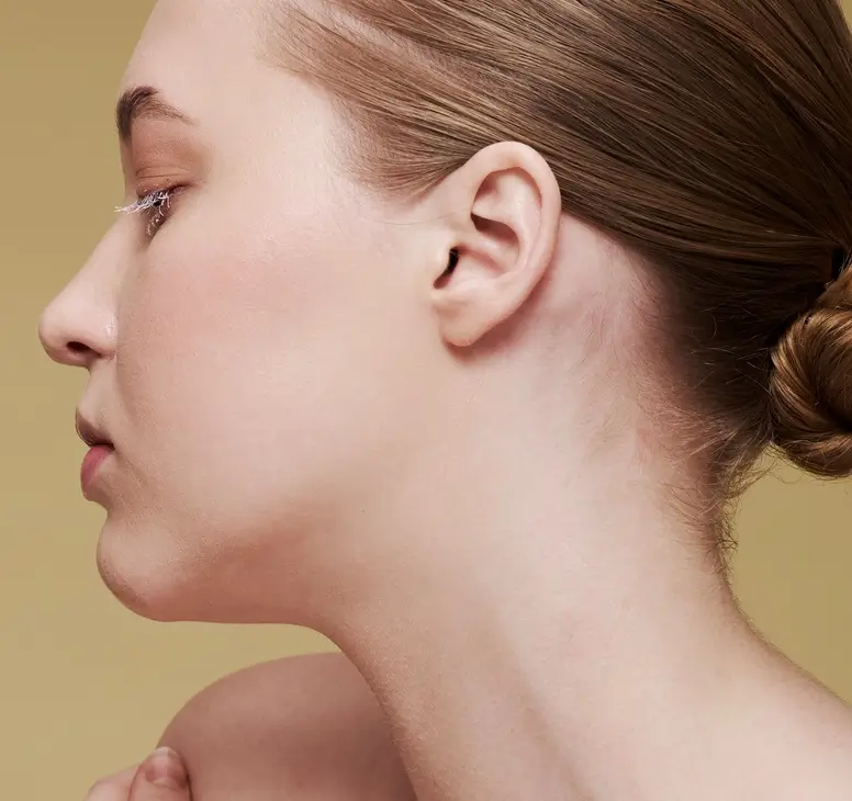 a woman is showing her face and neck from the side