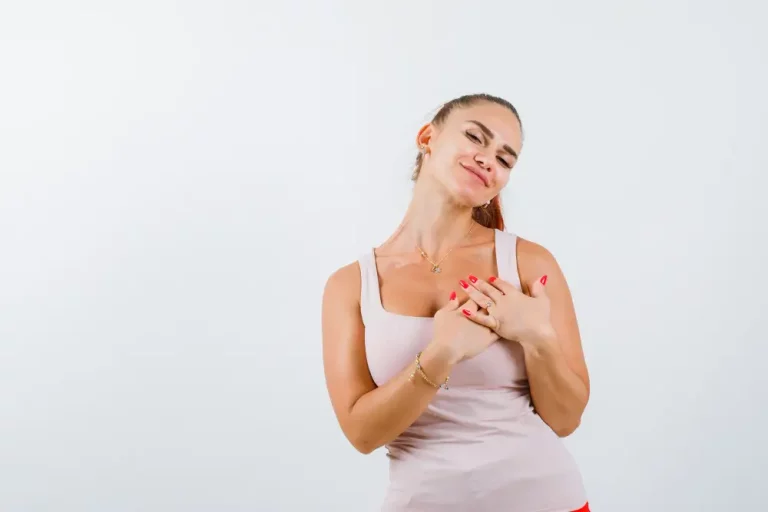 A woman holding her breasts, happy with the results of her breast reduction surgery in turkey