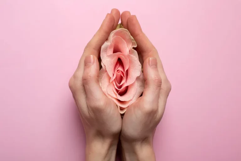 hands holding a pink flower resembling vagina after a labiaplasty in turkey