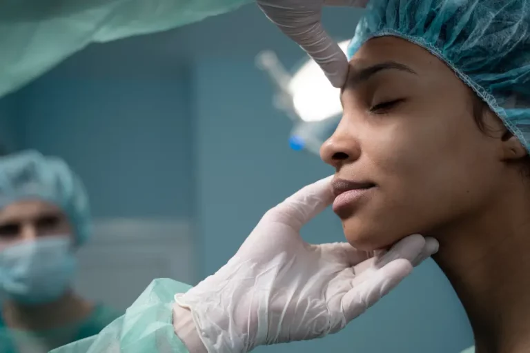 a woman's nose is examined for a secondary rhinoplasty surgery in turkey